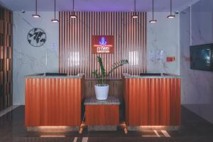 een lobby met twee oranje toonbanken met een potplant bij Lyz Business Hotel Piura in Piura