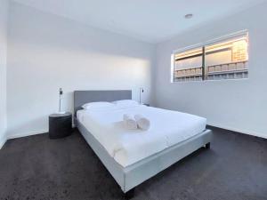 um quarto branco com uma cama grande e 2 toalhas brancas em Modern retreat. Pets welcome em Moama