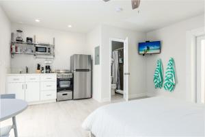 a white kitchen with a bed and a refrigerator at Ocean Flats 4 - Lauderdale-by-the-Sea in Fort Lauderdale