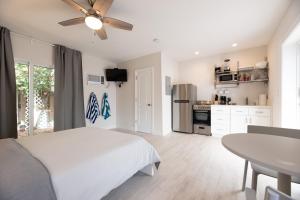 a white bedroom with a bed and a table at Ocean Flats 3 - Lauderdale-by-the-Sea in Fort Lauderdale