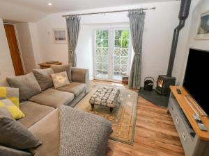 a living room with a couch and a fireplace at Riverside Cottage in Amlwch