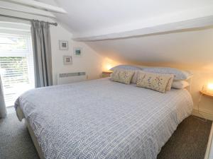 Schlafzimmer mit einem großen Bett mit blauer und weißer Bettwäsche in der Unterkunft Riverside Cottage in Amlwch