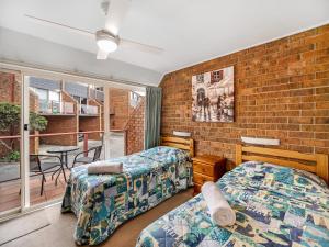 a bedroom with two beds and a brick wall at Pacific Heights in Merimbula +46 photos