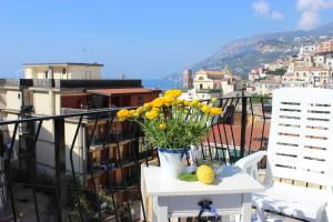 - une table avec un vase de fleurs sur le balcon dans l'établissement Casa Blu Cobalto, à Maiori