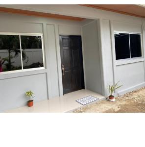 una porta d'ingresso di una casa con due finestre di Casas Rojas a Puerto Viejo