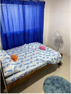 - une chambre avec un lit doté d'un rideau bleu dans l'établissement Casas Rojas, à Puerto Viejo