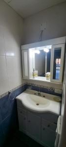 een badkamer met een witte wastafel en een spiegel bij FORMOSA RELAX in Formosa