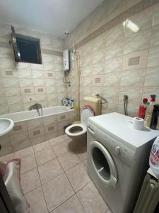 a bathroom with a washing machine and a toilet at Villa Magnifica in Strumica