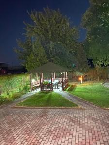 a gazebo with a picnic table in a park at night at Villa Magnifica in Strumica