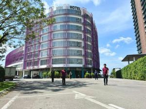 people walking in a parking lot in front of a hotel at Win Hotel in Sibu