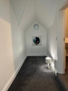 Habitación blanca con reloj en la pared en Juz Apartments Manchester airport en Altrincham