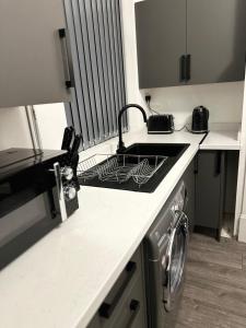 a kitchen with a sink and a stove top oven at Juz Apartments Manchester airport in Altrincham