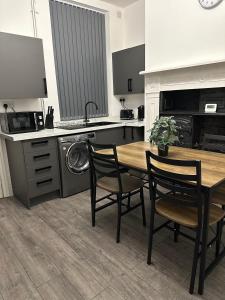 a kitchen with a table and chairs and a sink at Juz Apartments Manchester airport in Altrincham