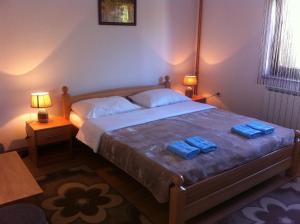 a bedroom with a bed with two blue towels on it at House Pribić in Vrelo Koreničko