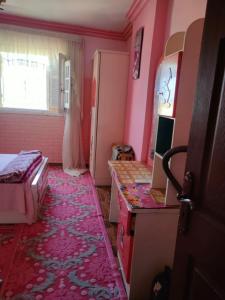 Habitación con paredes rosas y dormitorio con cama. en شقه فاخره للايجار بكامب شيزار, en Alejandría