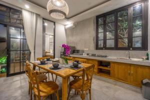Lavina Ubud Villas في أوبود: غرفة طعام مع طاولة وكراسي خشبية