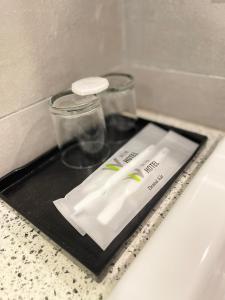 a black tray with two toothbrushes on a bathroom counter at Win Hotel in Sibu