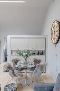 a dining room with a table and chairs and a clock at Stylish 1BD Flat 5 Mins to Harrods- Knightsbridge in London