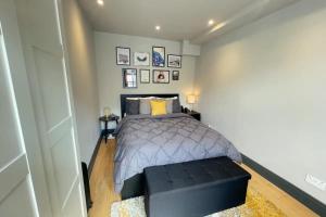倫敦的住宿－Contemporary 1BD Flat wGarden - Whitechapel，一间卧室配有一张带黑色长凳的床