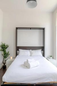 a bedroom with a white bed with towels on it at Incredibly Located Studio Flat - Camden Town in London