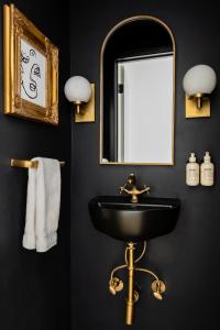 a black bathroom with a sink and a mirror at MrNomad Boutique Hotel Parisian Townhouse in Dallas +34 photos
