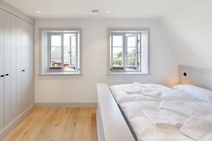 a white bedroom with two windows and a bed at Westport in List