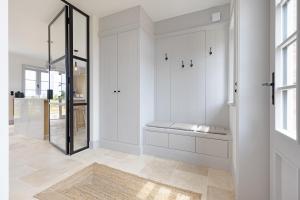 a white hallway with a bench and a glass door at Westport in List +68 photos