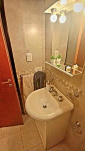 een badkamer met een witte wastafel en een spiegel bij BeelApt - Departamento elegante y seguro, con Cochera Exclusiva in La Plata