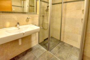 łazienka z umywalką i prysznicem w obiekcie Alpin & Seeresort Top 10 - by Alpen Apartments w mieście Zell am See +19 zdjęć