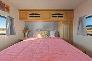 duże różowe łóżko w pokoju z oknami w obiekcie JT Village Campground - Star Stream w mieście Joshua Tree