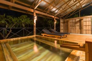 a swimming pool in a house with a wooden deck at Finca Amistad Cacao Lodge in Bijagua