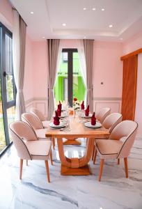 uma sala de jantar com uma mesa de madeira e cadeiras em Trân Châu Beach & Resort em Ba Ria