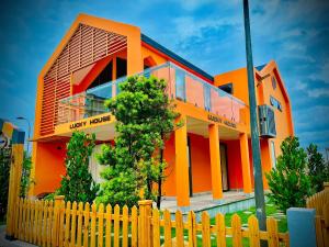 una casa naranja con una valla delante de ella en Trân Châu Beach & Resort, en Bà Rịa
