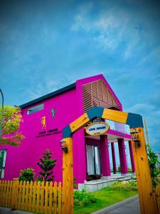 Um edifício cor-de-rosa com uma vedação à frente. em Trân Châu Beach & Resort em Ba Ria