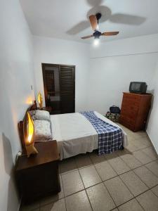 um quarto com uma cama e uma ventoinha de tecto em Ubatuba-Itaguá em Ubatuba