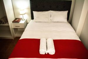 a red and white bed with two towels on it at Miski Wasi in Cusco