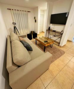 uma sala de estar com um sofá e uma televisão de ecrã plano em Paramont Rosario 2 em Rosario de la Frontera