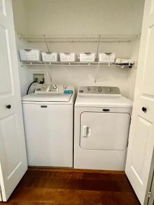 lavandería con 2 lavadoras y estanterías en Kellogg Haus, 