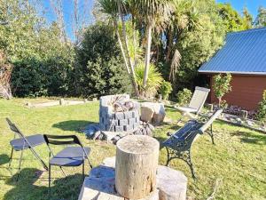 un patio con 2 sillas y chimenea en Dakune Chill - The Lodge, en Ohakune