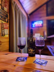 dos copas de vino sentadas en una mesa con una botella de vino en Dakune Chill - The Lodge, en Ohakune