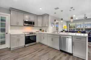 a kitchen with white cabinets and stainless steel appliances at Modern getaway near the beach with room for a boat in West Palm Beach