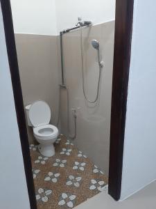 a bathroom with a shower and a toilet at Riung Tiga Empat Tujuh Guesthouse in Riung