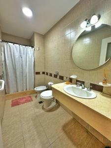 uma casa de banho com um lavatório, um WC e um espelho. em Paramont Rosario 2 em Rosario de la Frontera