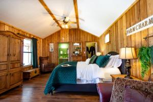 ein Schlafzimmer mit einem Bett in einem Zimmer mit Holzwänden in der Unterkunft A Barn At The Quarry in Fredericksburg