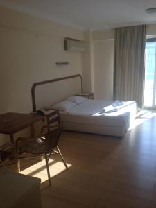 チェシメにあるZeytin Apart Hotelのベッドルーム1室(ベッド1台、テーブル、椅子付)