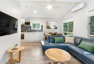 a living room with a blue couch and a table at Reflections Scotts Head - Holiday Park in Scotts Head