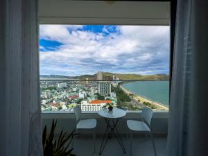 a view of a city from a window with a table and chairs at Grand Hyams Hotel - TMS Tầng 21 View Biển Quy Nhơn - 2PN in Quy Nhon