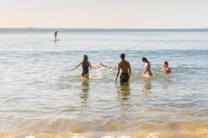 a group of people standing in the water at Halse Lodge Noosa Heads in Noosa Heads