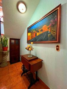 a hallway with a table with a painting on the wall at CasaDe Leon-Hotel Boutique in Antigua Guatemala