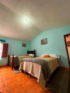 a bedroom with two beds and blue walls at CasaDe Leon-Hotel Boutique in Antigua Guatemala